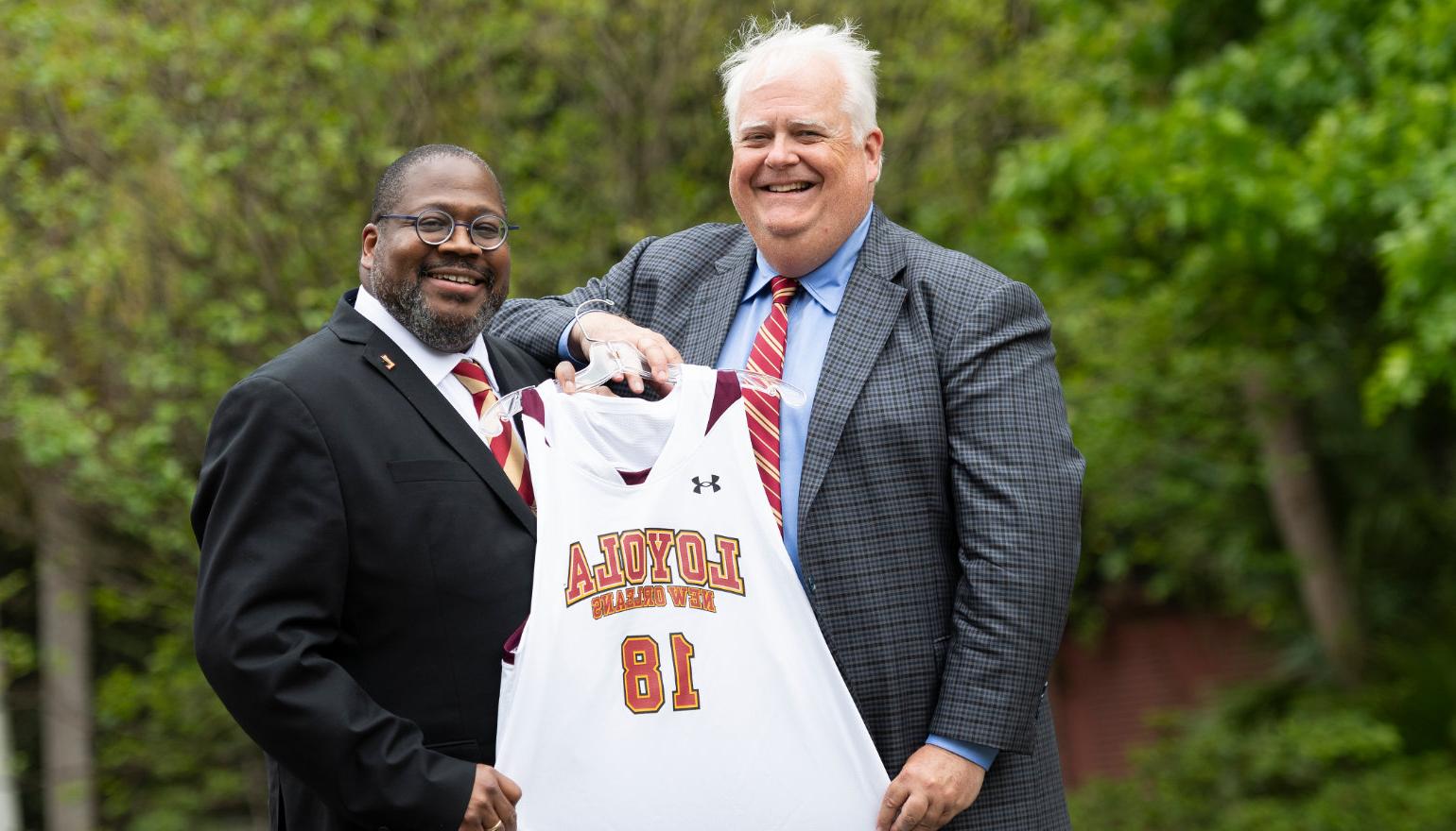 Stephen Landry '83, chair of the 校董会, presents Dr. Xavier Cole with a #18 basketball jersey
